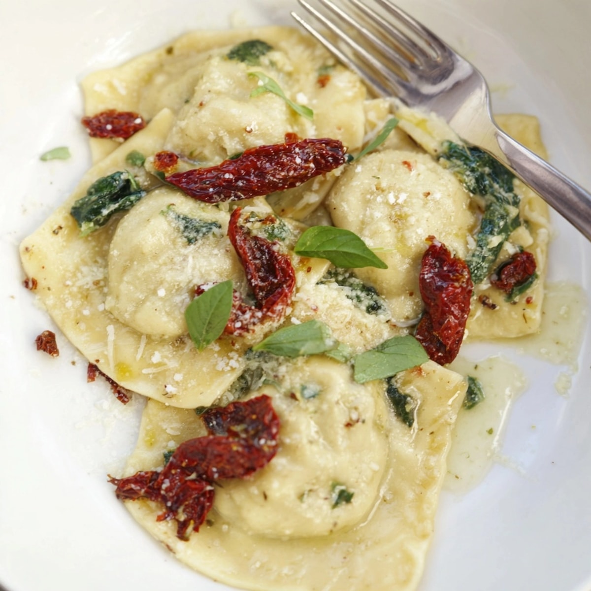 Imagine perfectly cooked Sun-Dried Tomato Spinach Ravioli, plated and ready to enjoy with basil.