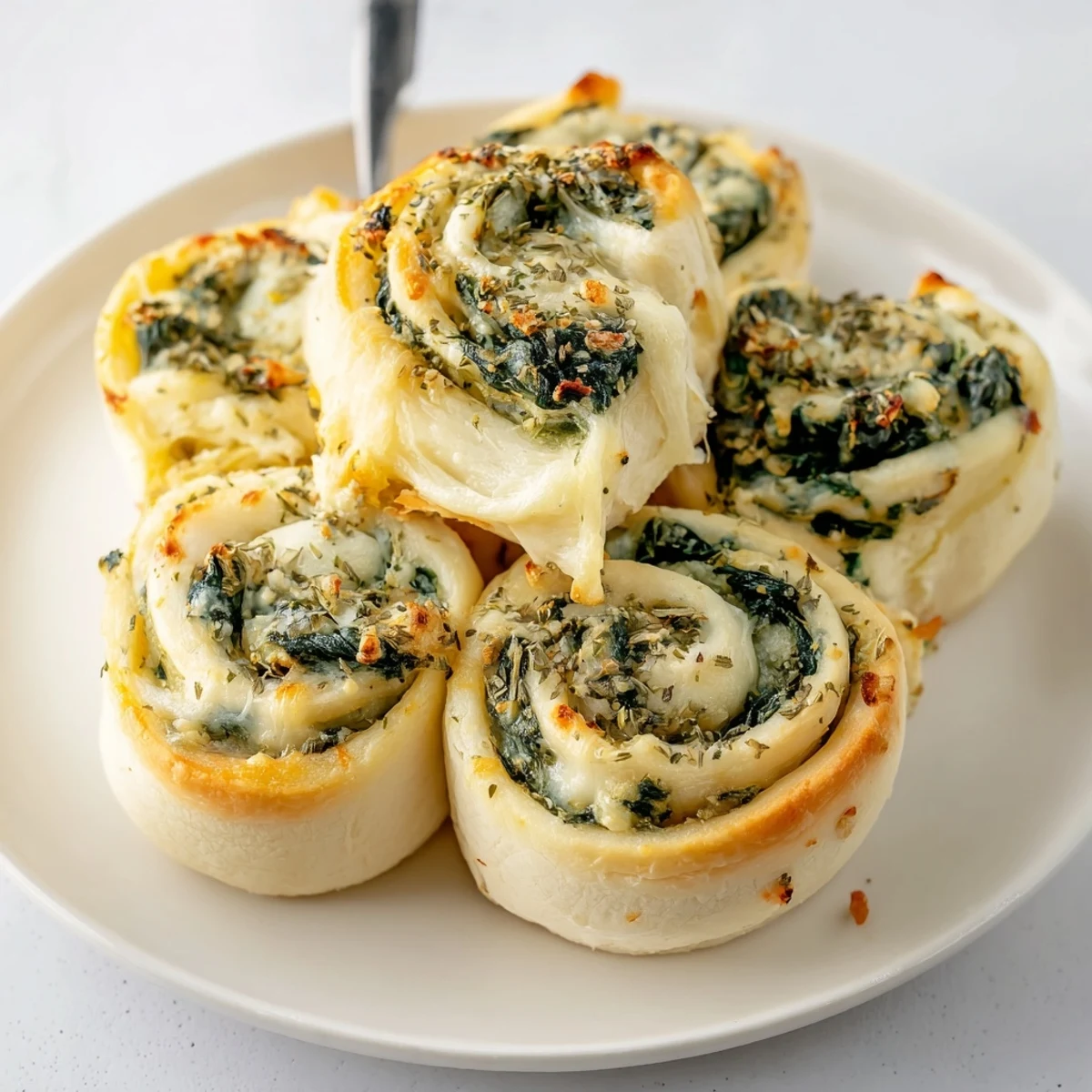 Golden pizza rolls bursting with Alfredo Garlic Spinach filling, ideal for snacks.  