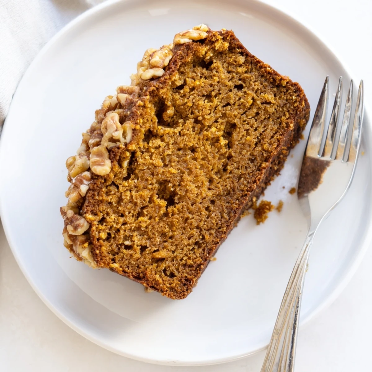 Warm, spiced pumpkin bread loaf, golden brown with optional nuts, perfect for fall flavors.