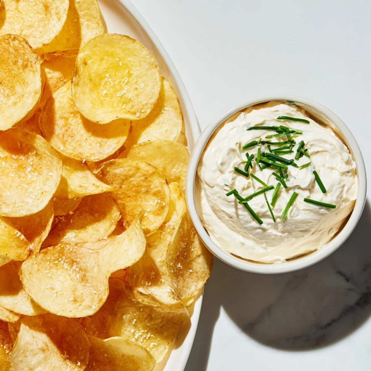 Golden-brown potato chips ready to be dipped into a flavorful homemade onion dip.