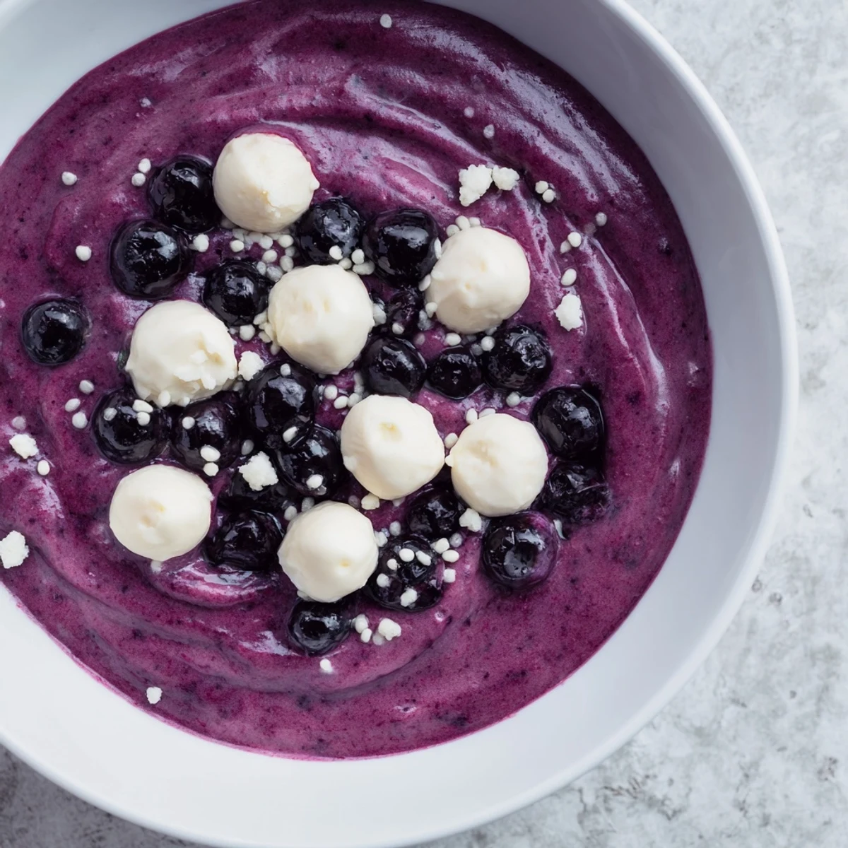 A visually appealing Galaxy Spiral, showcasing goat cheese "stars" on swirled yogurt with blackberry jam.