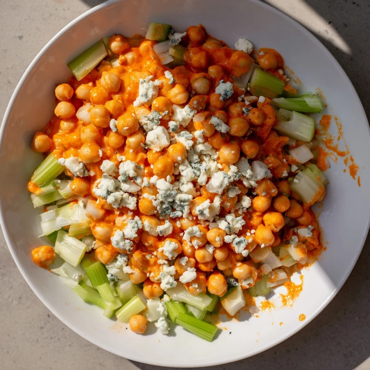 Vibrant photo showcases buffalo chicken bean salad, a spicy vegetarian delight with blue cheese crumbles.