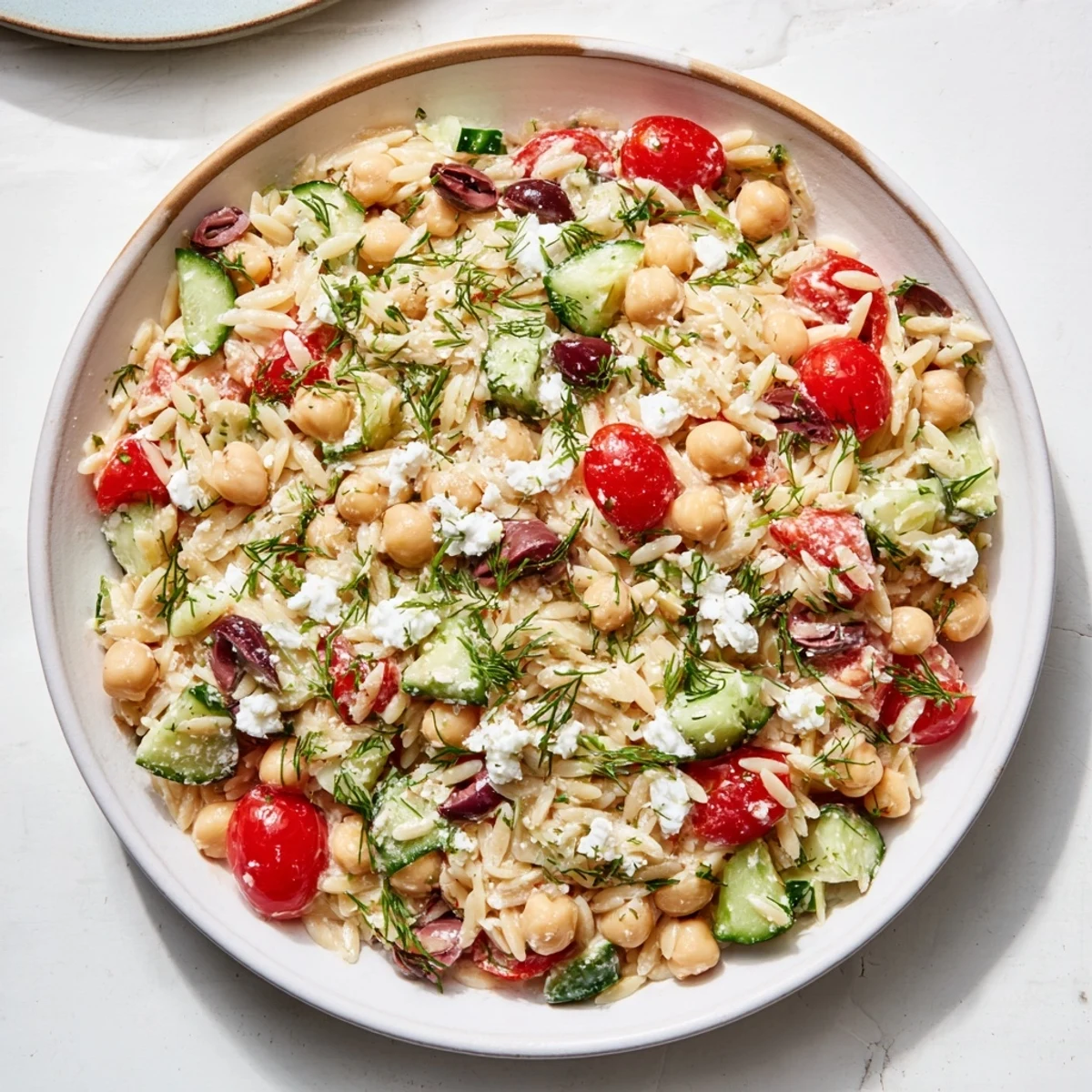Fresh Greek Lemon-Orzo Bean Salad with bright tomatoes, cucumbers, and a zesty vinaigrette.