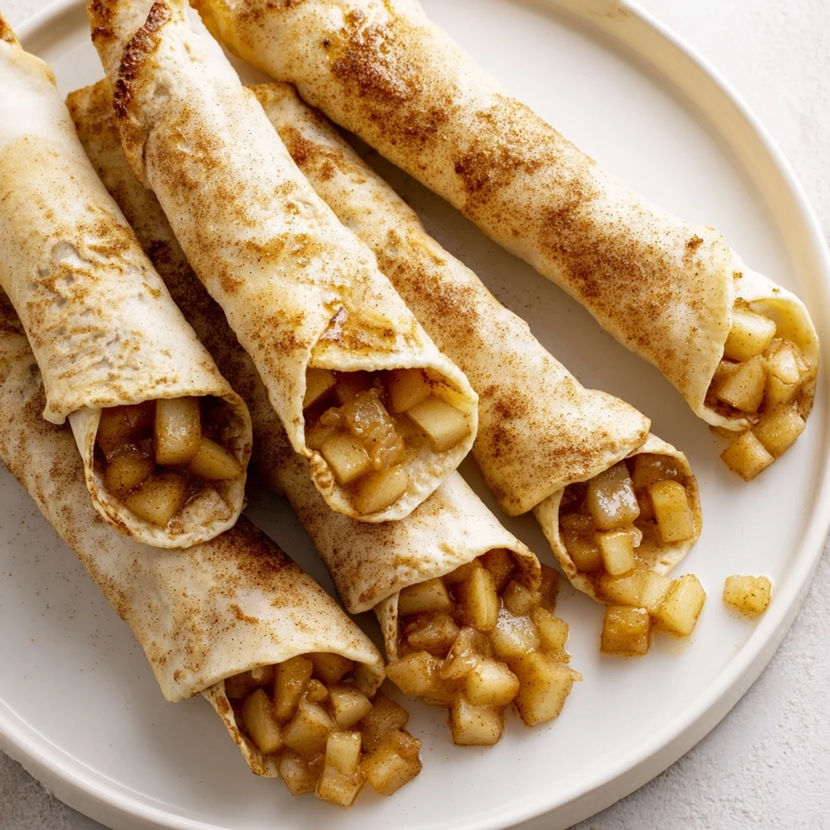Warm and inviting close-up of baked Apple Pie Roll-Ups, highlighting spiced apple filling.