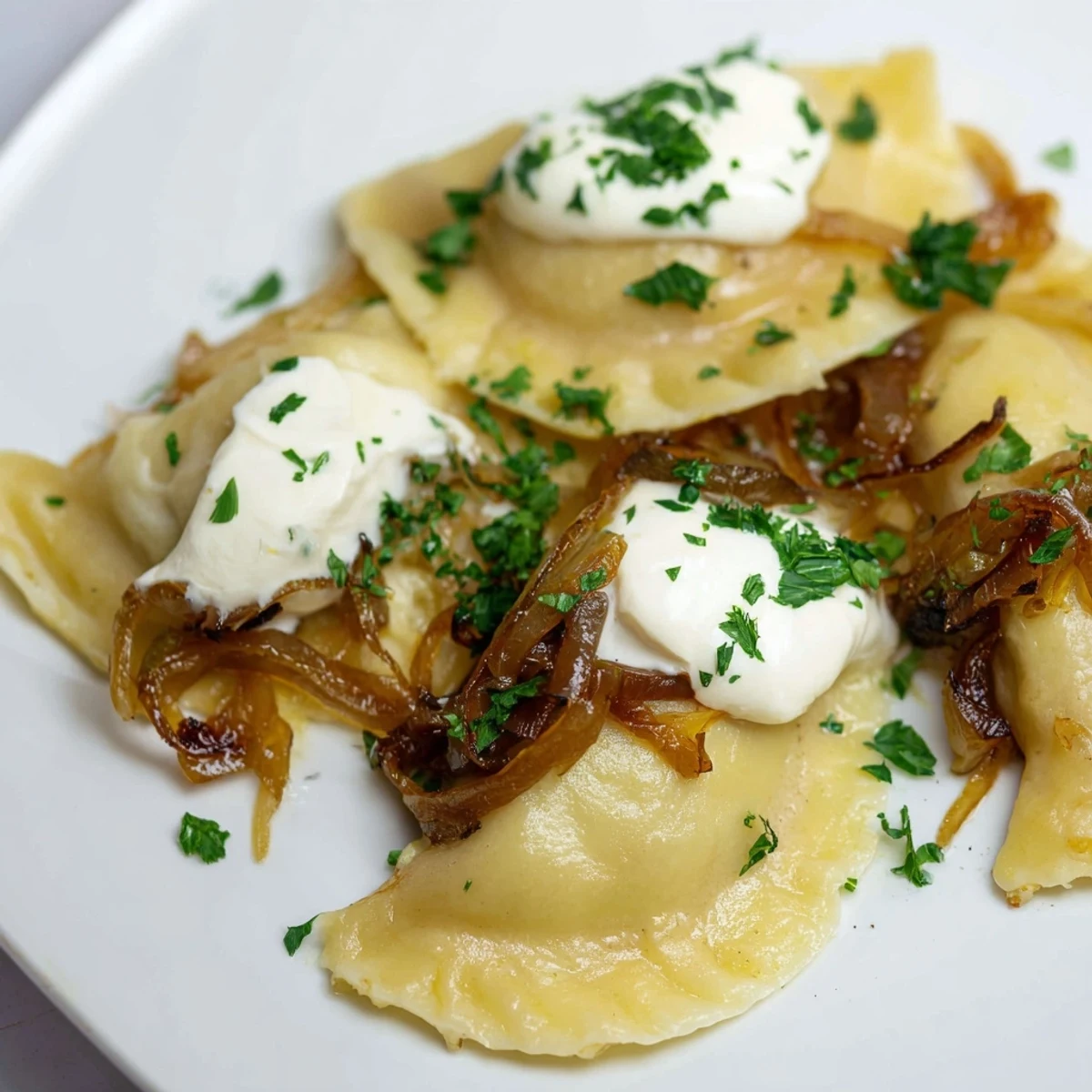 Golden, crispy Polish pierogi dumplings are served with sweet caramelized onions, a delicious dish.