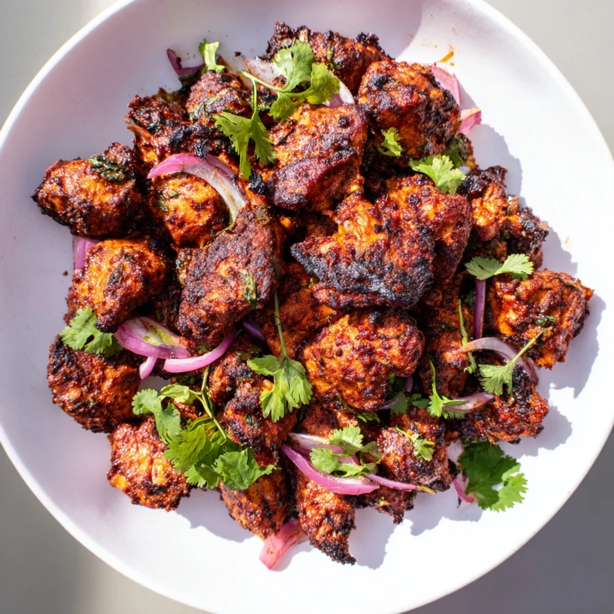 Close-up of juicy Indian Tikka Spiced Chicken with visible seasonings, ready to serve with rice.