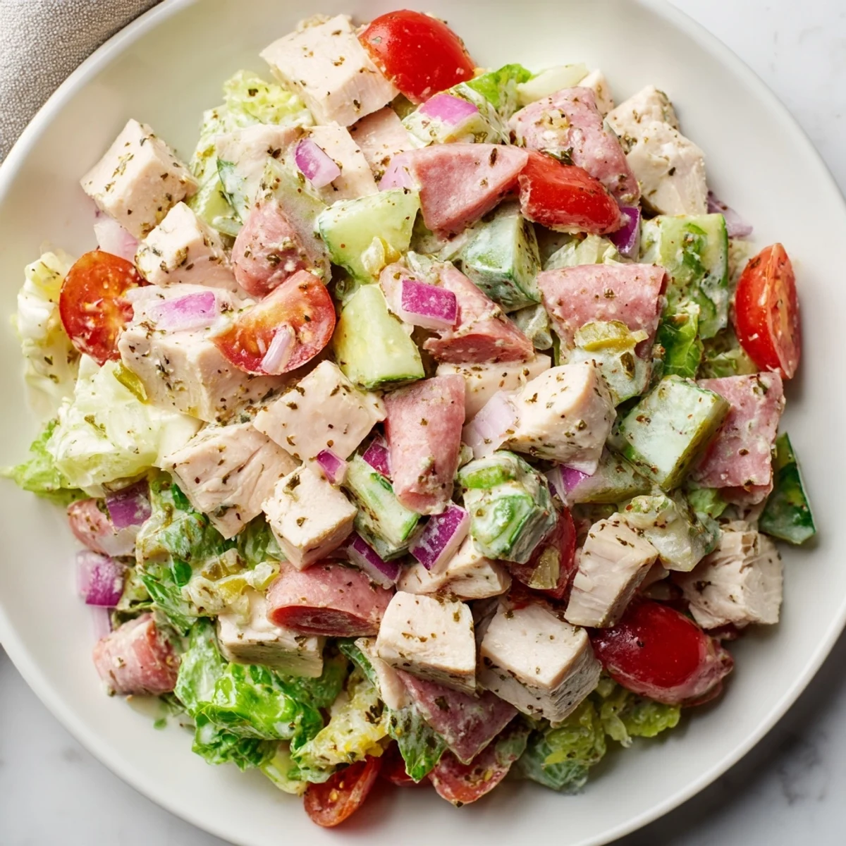 A colorful view of Italian Deli Chopped Chicken Salad, featuring salami and pepperoncini, ready to serve.