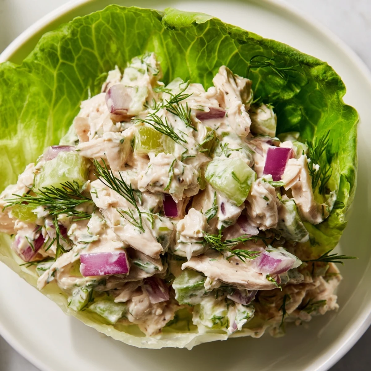 Vibrant Dill Pickle Chicken Salad served in crisp butter lettuce cups, ready to enjoy.