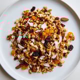 Close-up of golden Mélange Hivernal Flocon de Neige, perfect for a festive snack, in a wooden bowl.