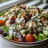 Serving suggestion: chilled Tzatziki Chicken Salad over fresh spinach, ready for a light lunch or refreshing dinner.