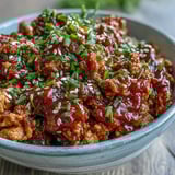 Heaping spoonfuls of Korean-style ground turkey over fluffy steamed rice, garnished with toasted sesame seeds and chopped chives.  