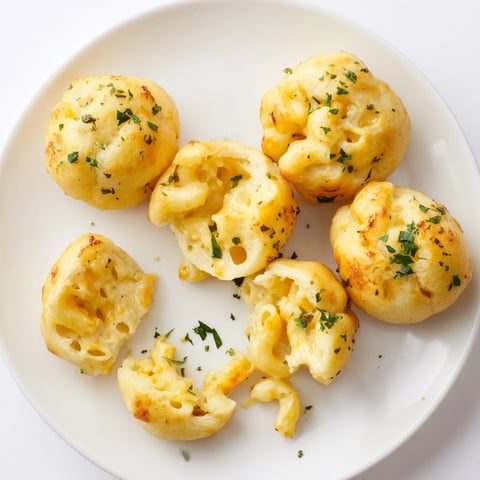 Close-up of golden Mac and Cheese Garlic Dough Balls, glistening with buttery garlic.