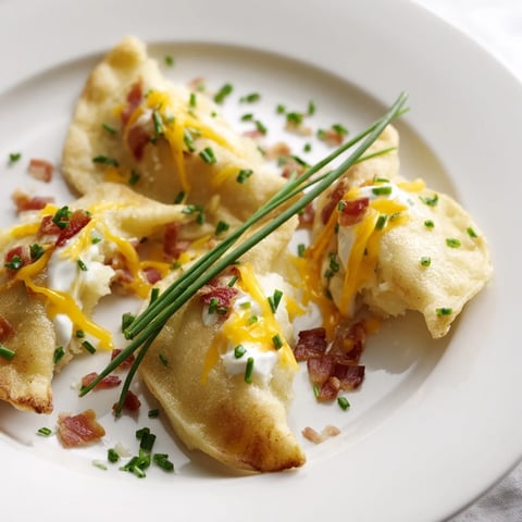 Steaming Loaded Baked Potato Soup Dumplings, golden from a quick pan-fry, ready to be enjoyed as a starter.