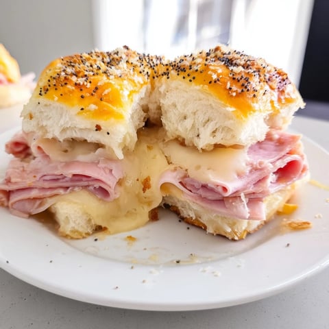 Golden, bubbly Budget-Friendly Ham & Cheese Sliders, showcasing layers of savory ham and melted cheese.