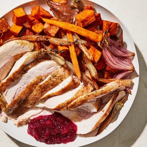 A Harvest Turkey Platter featuring juicy, roasted turkey breast beside colorful autumn vegetables.