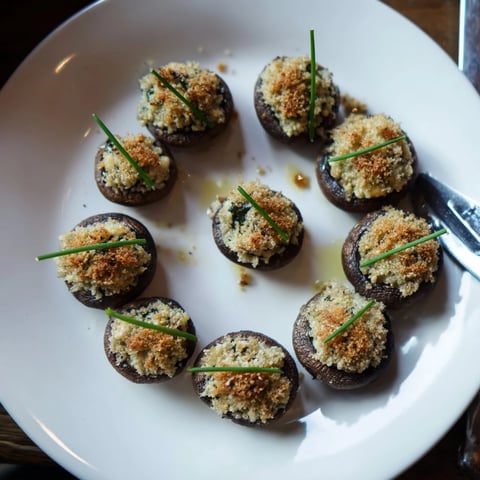 Golden-brown stuffed mushroom caps arranged in ring, perfect for a flavorful appetizer.