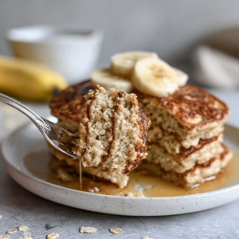 A stack of pancakes with bananas on top.