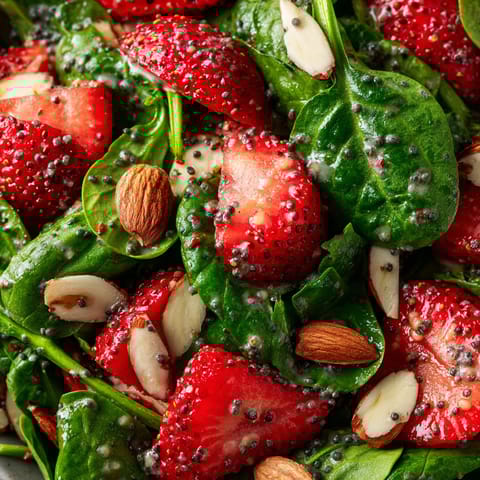 A salad with strawberries and spinach.