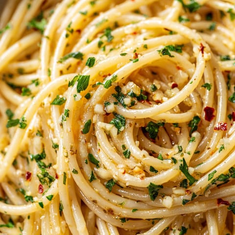 A close up of a bowl of spaghetti with herbs.