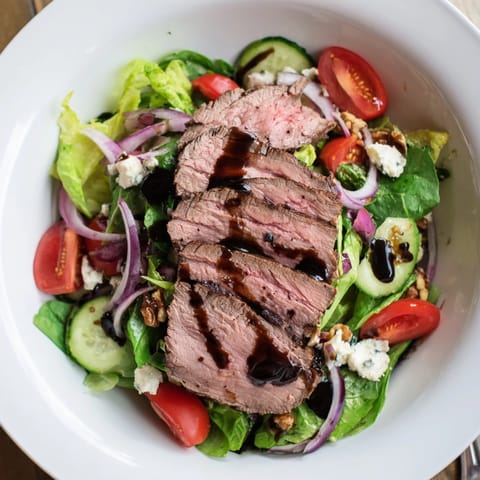 Balsamic Steak Gorgonzola Salad: A hearty main course with tangy vinaigrette drizzled on top.