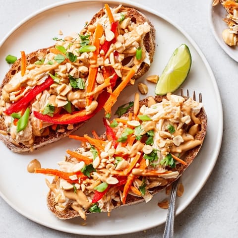 Colorful, spicy Thai Peanut Pinto Chicken Toast piled high on crispy sourdough.  