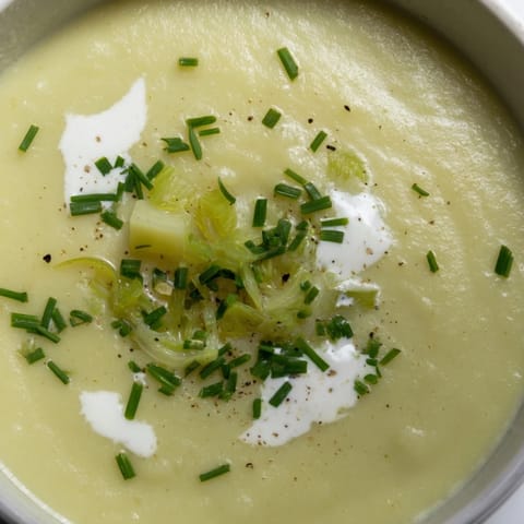 Velvety Creamy Potato & Leek Soup steaming hot beside crusty bread slices.  