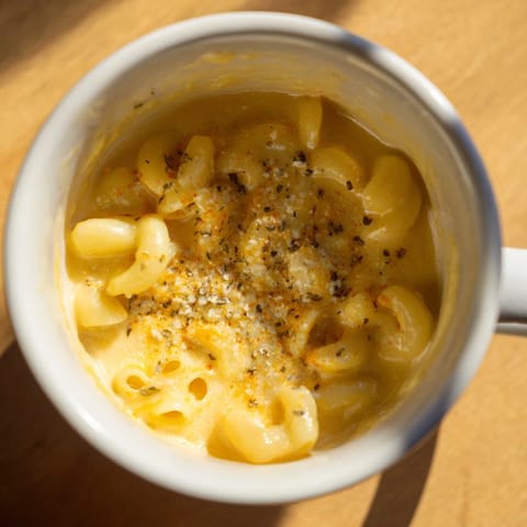 Cheesy, bubbly mug mac & cheese sprinkled with paprika, perfect for a quick lunch or dinner.
