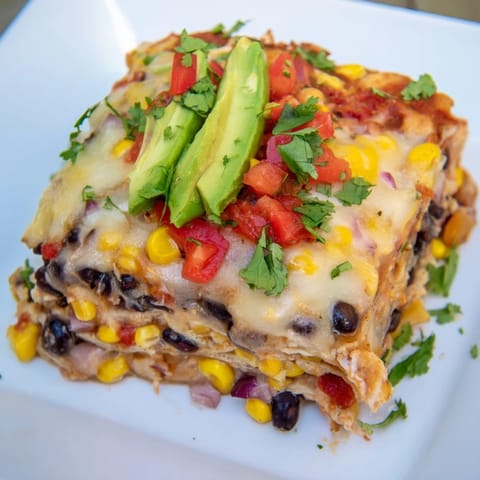 This Quick Black Bean and Corn Tortilla Casserole features layers of tortillas, beans, and corn with golden cheese.