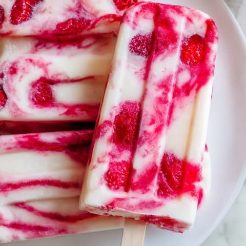 A close-up of delicious Raspberry Coconut Ice Pops: a refreshing, vegan dessert made with fresh raspberries.