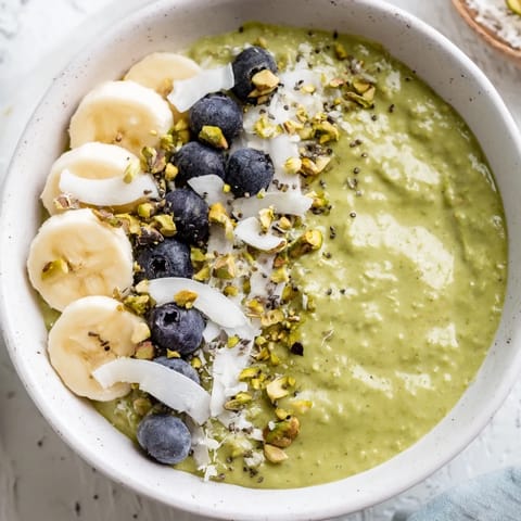 Vivid green matcha overnight oats, ready to eat with a swirl of honey, perfect breakfast.