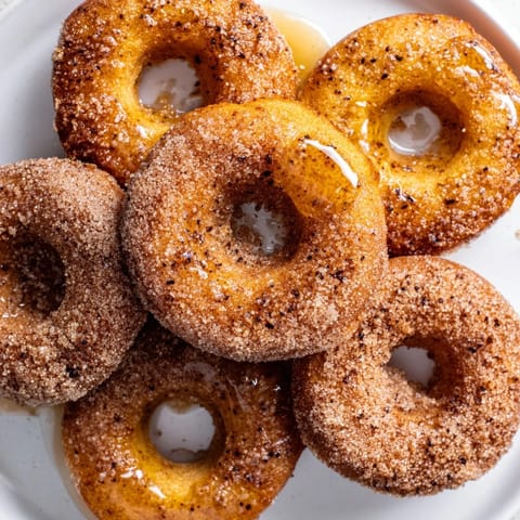Image capturing freshly air-fried 1-Minute Air Fryer Donuts, coated in cinnamon sugar, perfect for a quick dessert.