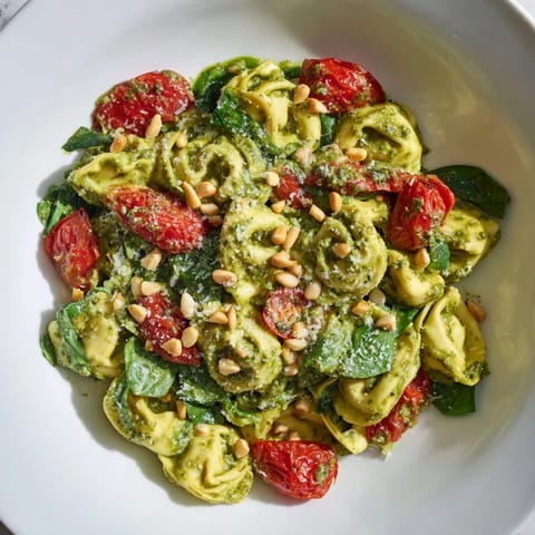 Cool, cooked tortellini tossed in vibrant pesto, perfectly complemented by juicy cherry tomatoes in this salad.