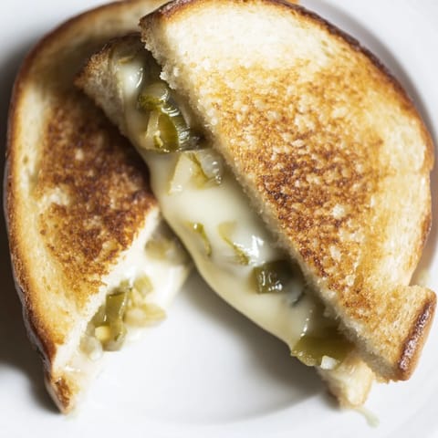 Savory jalapeño pepper jack grilled cheese, perfectly toasted, ready to be cut and served warm.