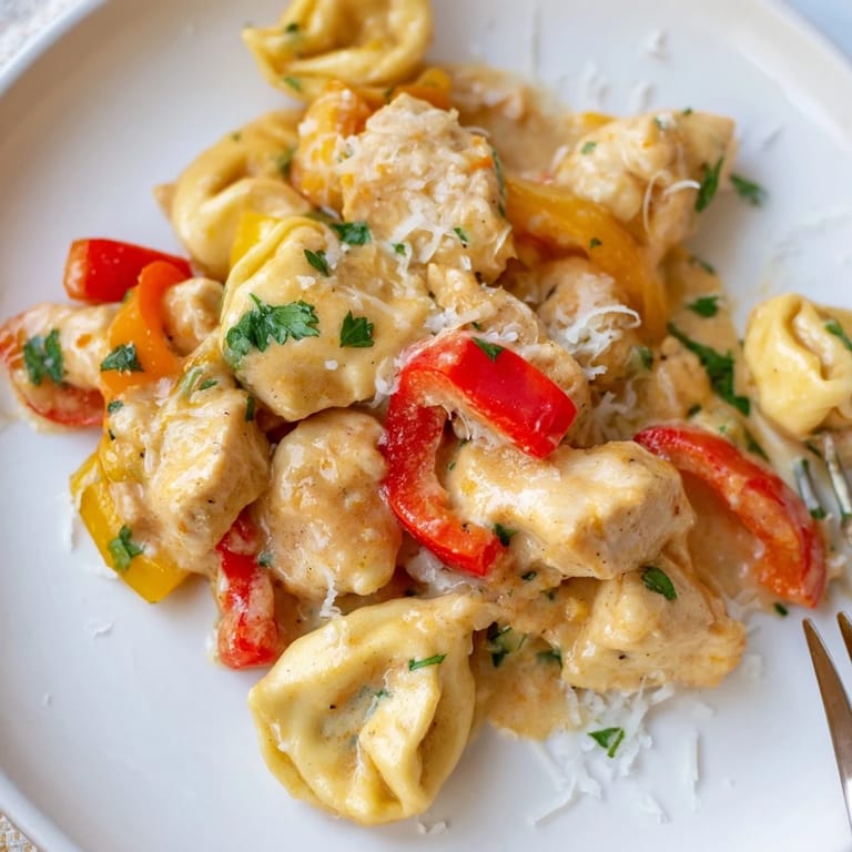 A vibrant plate of Zesty Cajun Garlic Parmesan Chicken Tortellini garnished with fresh parsley.  