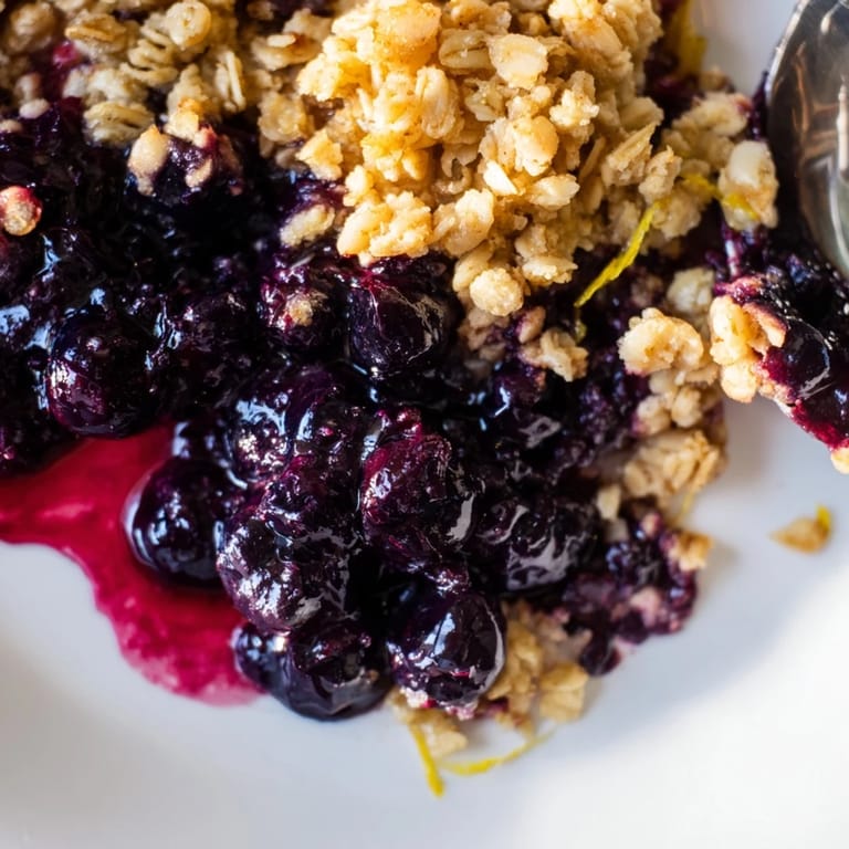 Irresistible blueberry & lemon crisp topped with ice cream, perfect for summer nights.