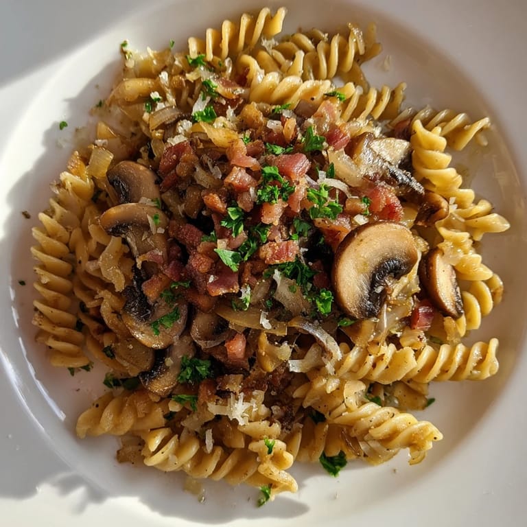 Golden-brown fusilli with bacon and onions, a hearty Italian-inspired dish ready to serve and enjoy.