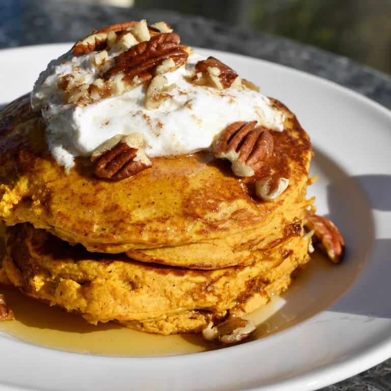 Stack of fresh-cooked Pumpkin Spice Pancakes, warm and inviting, ready to be enjoyed with family.