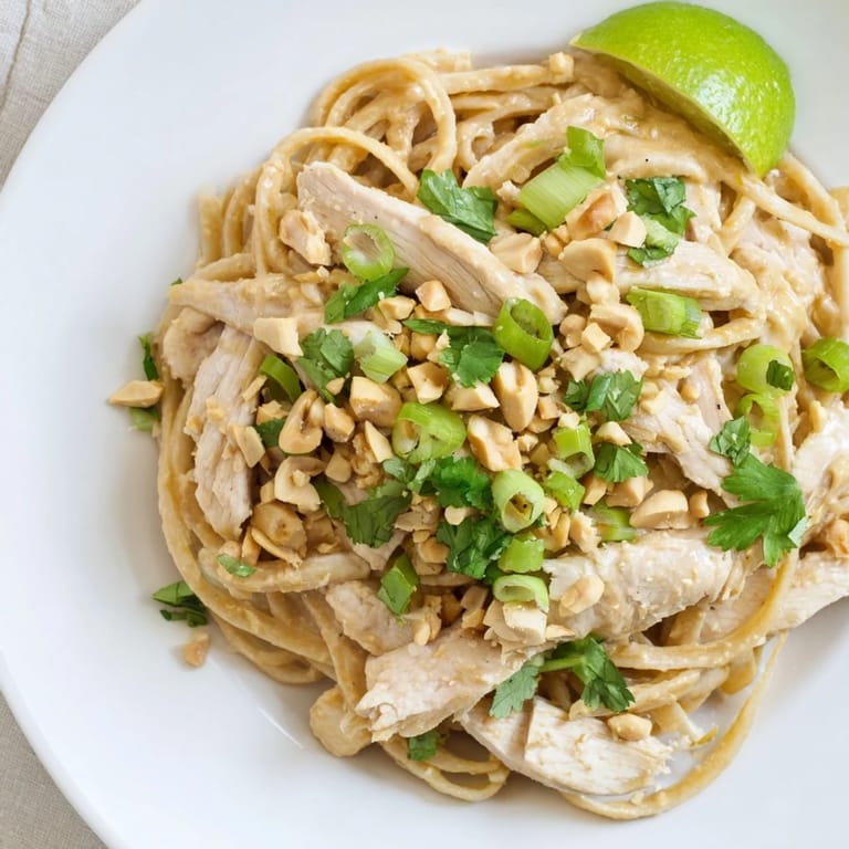 Tender chicken and linguine coated in savory Thai Peanut Chicken Pasta, ready to enjoy.