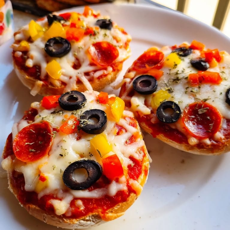 A close-up of cheesy mini bagel pizzas fresh from the air fryer, ideal for a quick appetizer.