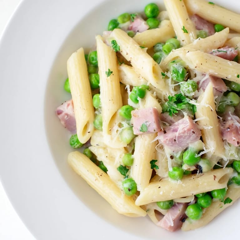 A comforting bowl of Spring Pea & Ham Pasta, showing tender penne, peas, and a rich, creamy sauce.