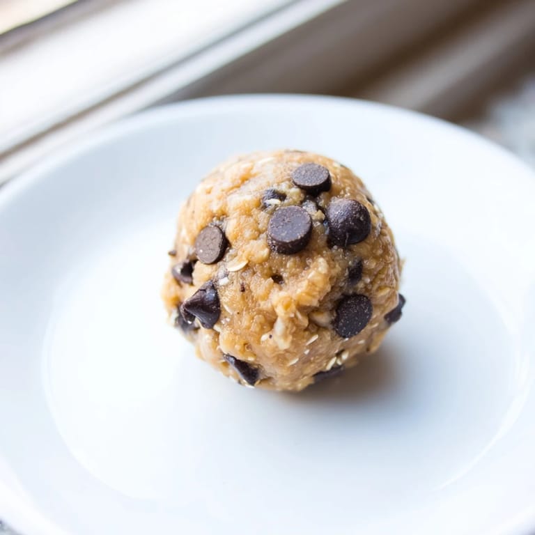 A plate of Banana Chocolate Chip Energy Balls with a drizzle of honey, ideal for a quick, healthy breakfast.