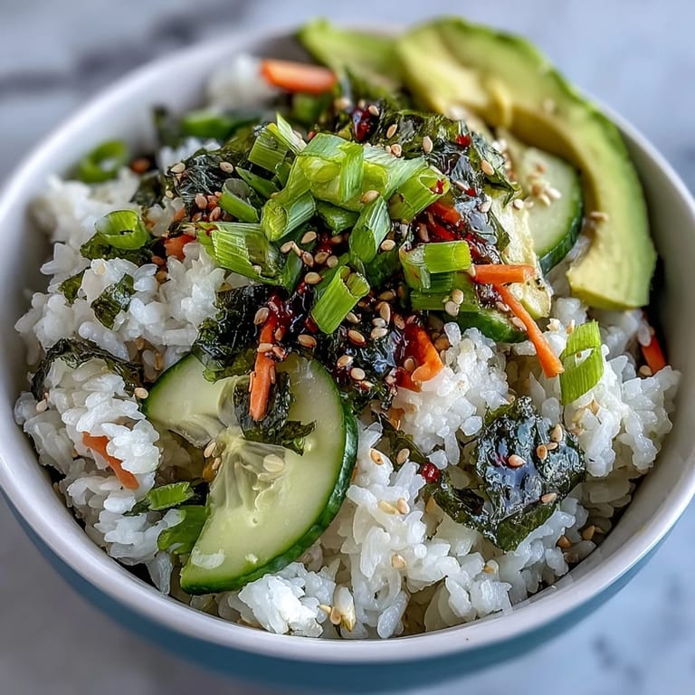 Deconstructed Seaweed Snack Sushi Bowl with sushi-grade salmon, pickled ginger, and carrots on a bed of seasoned Japanese rice.