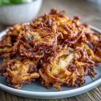 Crispy air fryer onion bhaji with golden edges and fragrant Indian spices, perfect as a healthy vegan snack or appetizer.